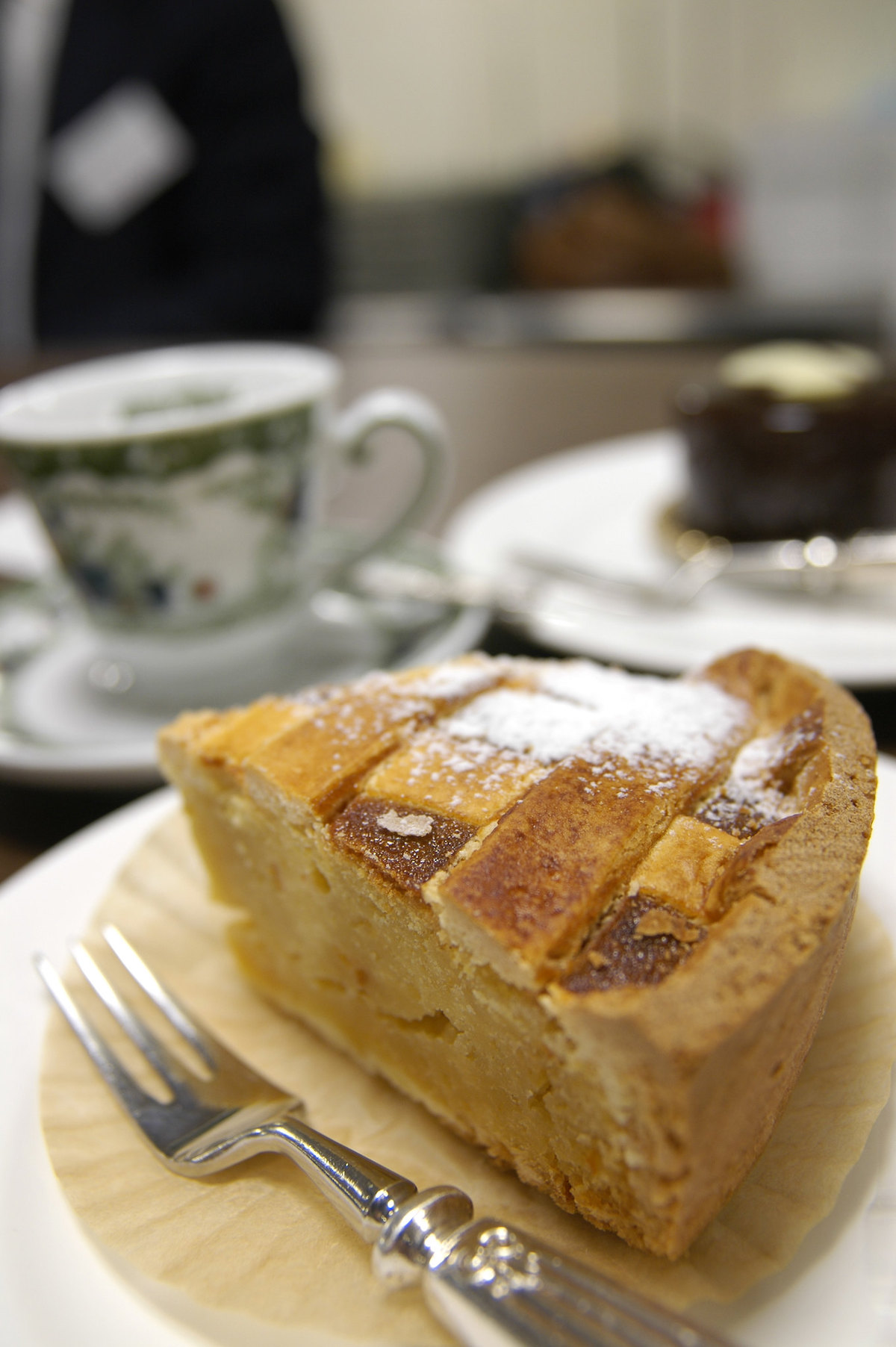 Una rebanada de pastiera napolitana, un pastel típico de Pascua, cerca de ella