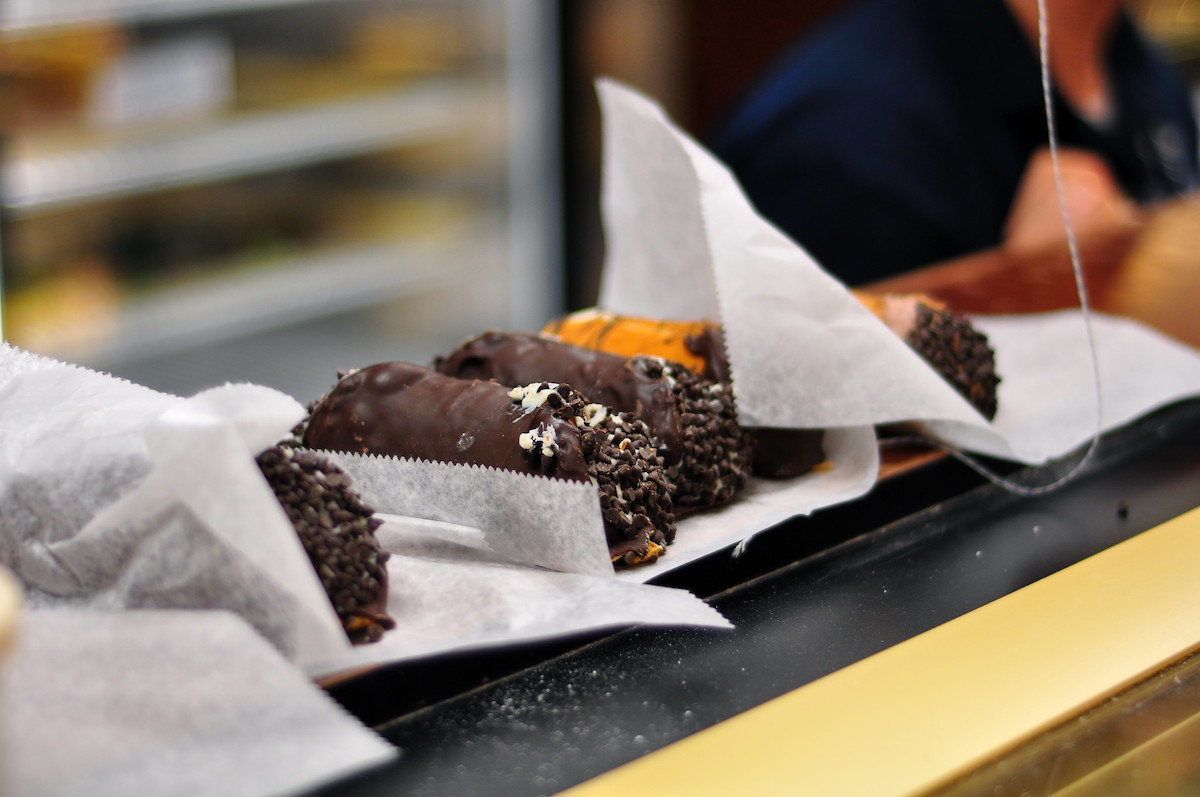 Cerca de tres cannoli en una hoja de papel de pastelería en el mostrador de Mike's Pastry, una de las mejores panaderías de Boston.