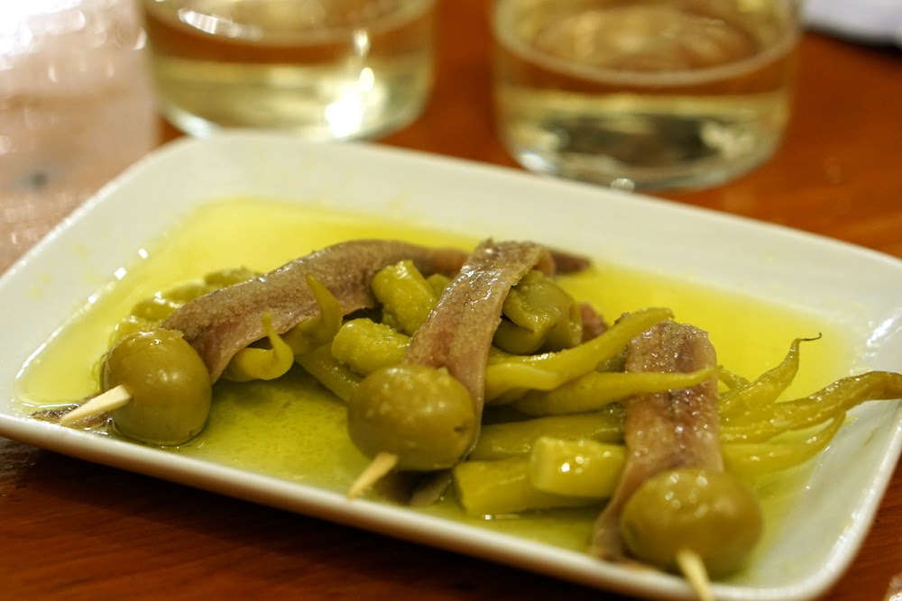 En muchos recorridos por los viñedos cerca de San Sebastián, tendrá la oportunidad de probar productos locales (como estos pinchos de anchoas y aceitunas) junto con su vino.