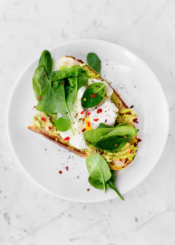 Tostada de aguacate con huevos escalfados y verduras de hoja verde