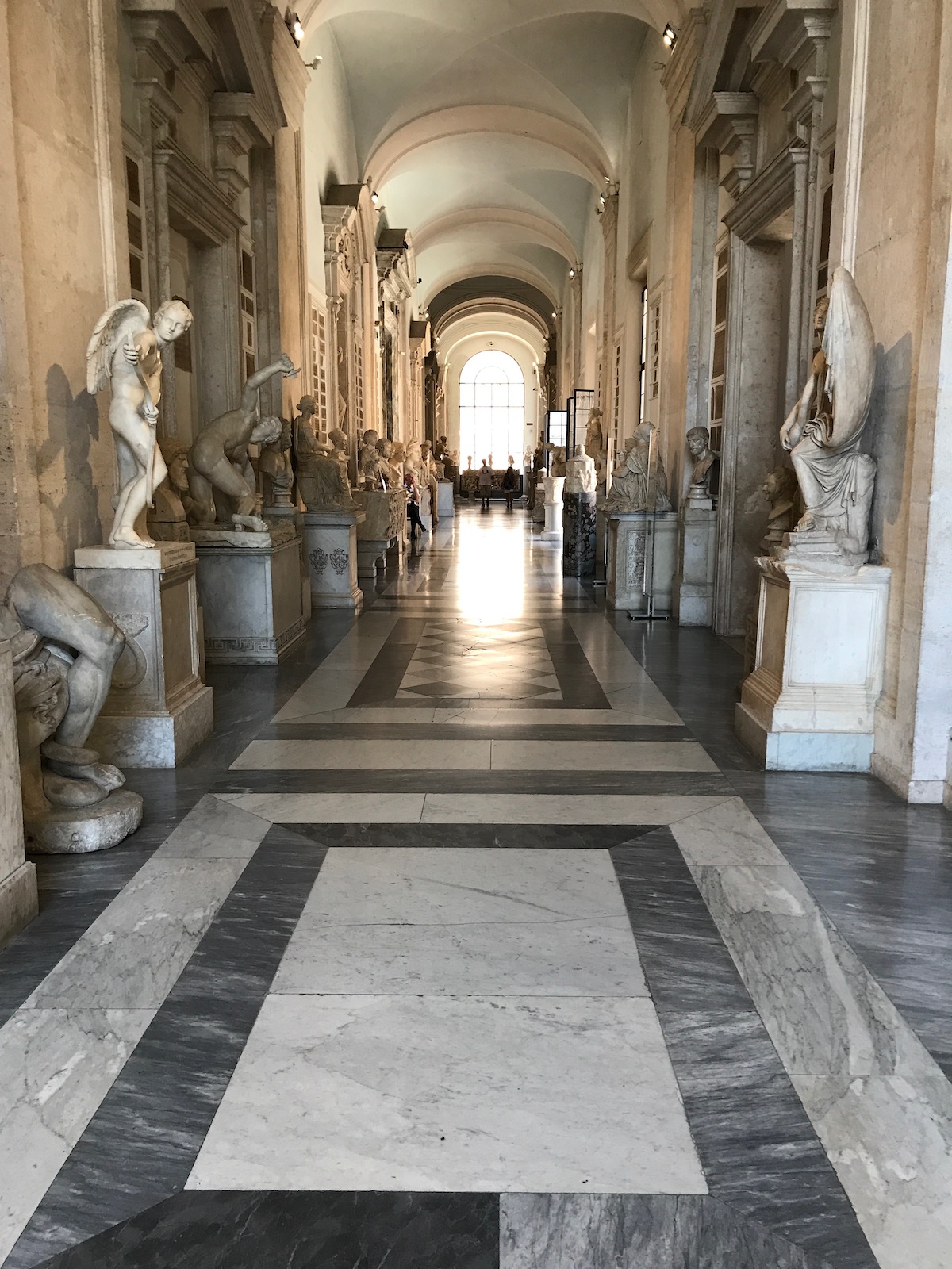 Un largo salón bordeado de estatuas de mármol dentro de los Museos Capitolinos en Roma.