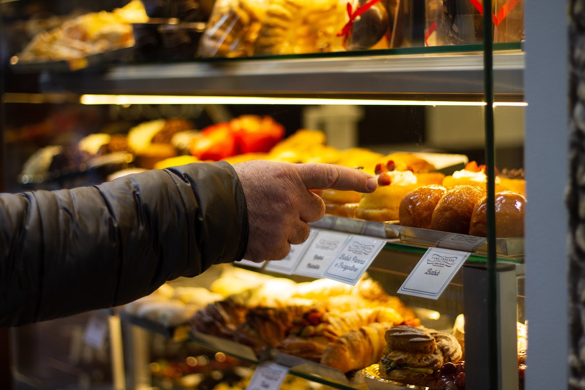 Alguien señala a un bebé dentro de una vitrina de pastelería en Nápoles