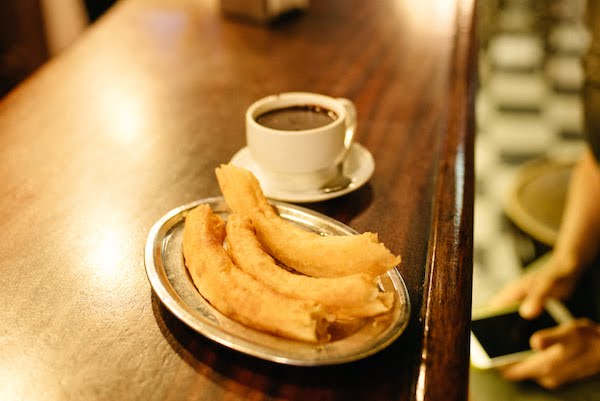 Churros y chocolate en una barra