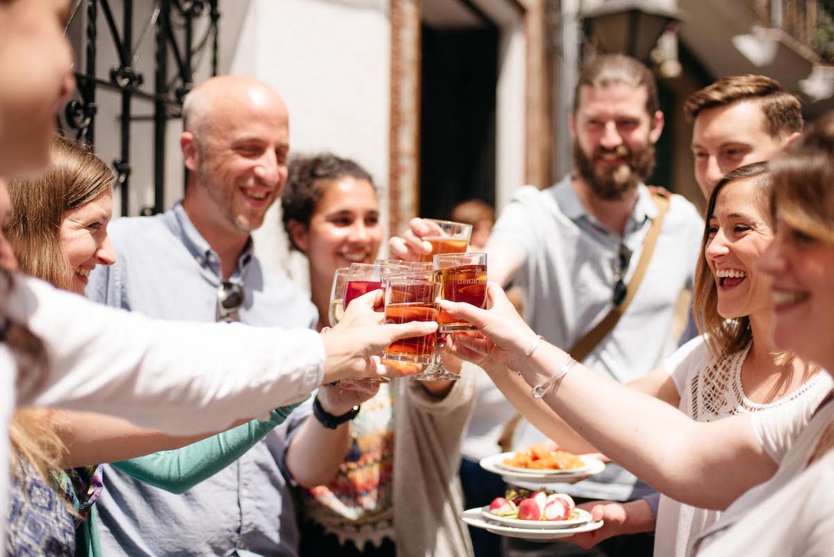Un grupo de personas sonriendo y brindando con bebidas.