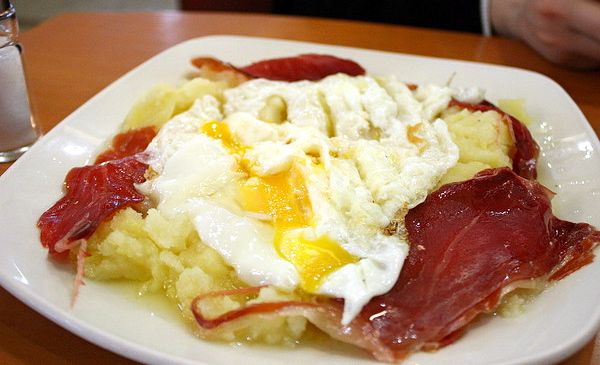 Huevos rotos españoles (huevos revueltos sobre patatas con jamón serrano)