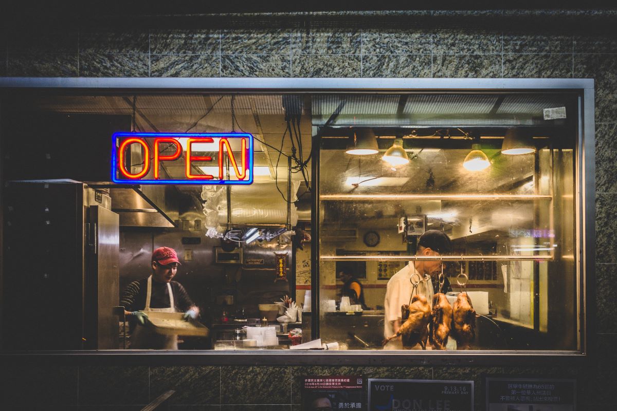 hombres cocinando dentro de un restaurante con luz de neón