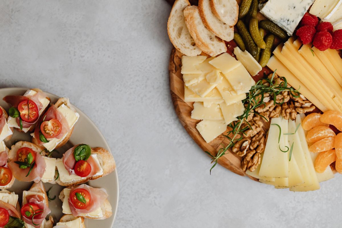 diferentes alimentos-sobre-mesa-de-charcuteria-y-plato-de-cerámica