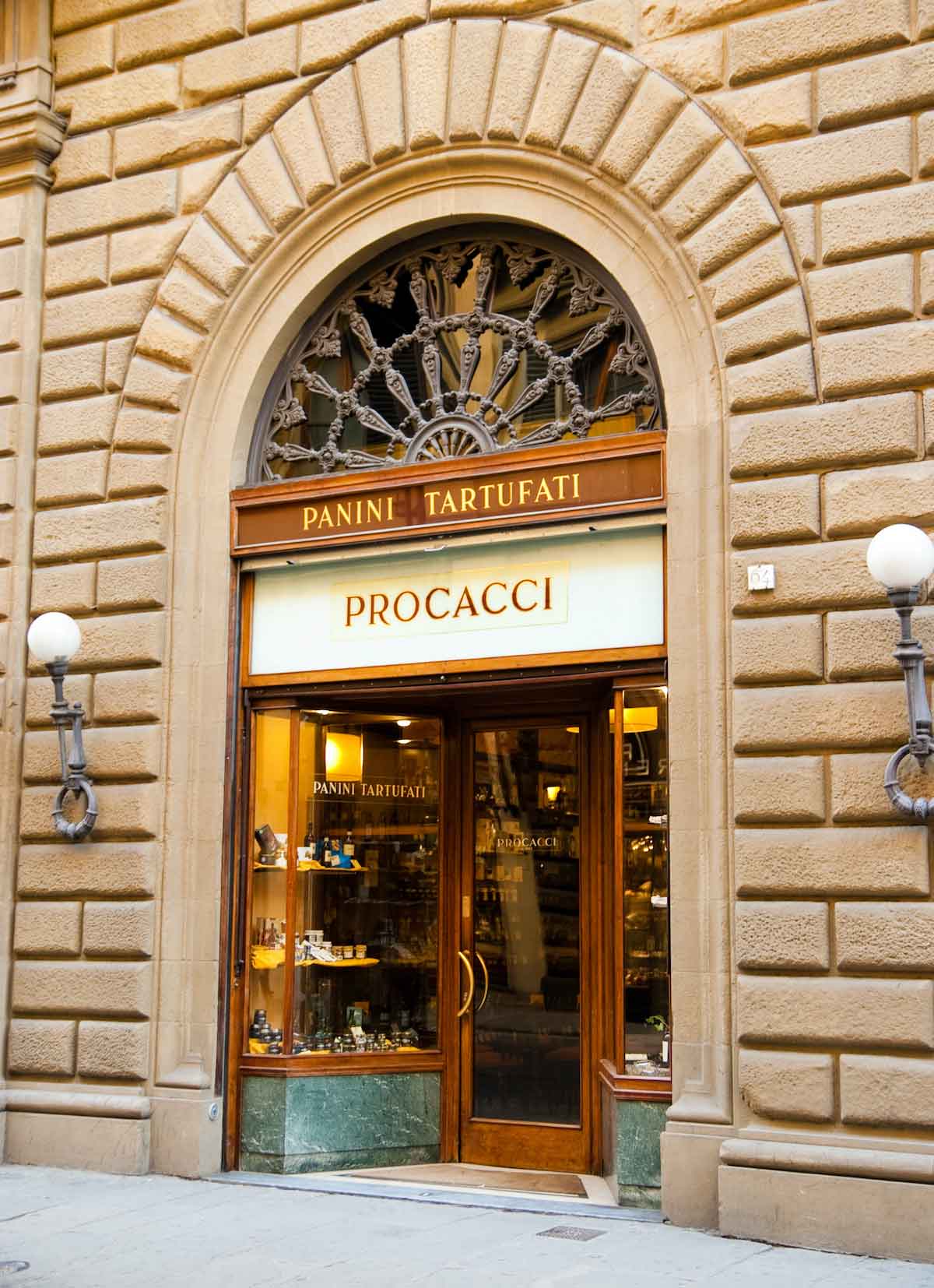 Exterior del restaurante Procacci en Florencia con una puerta de piedra arqueada