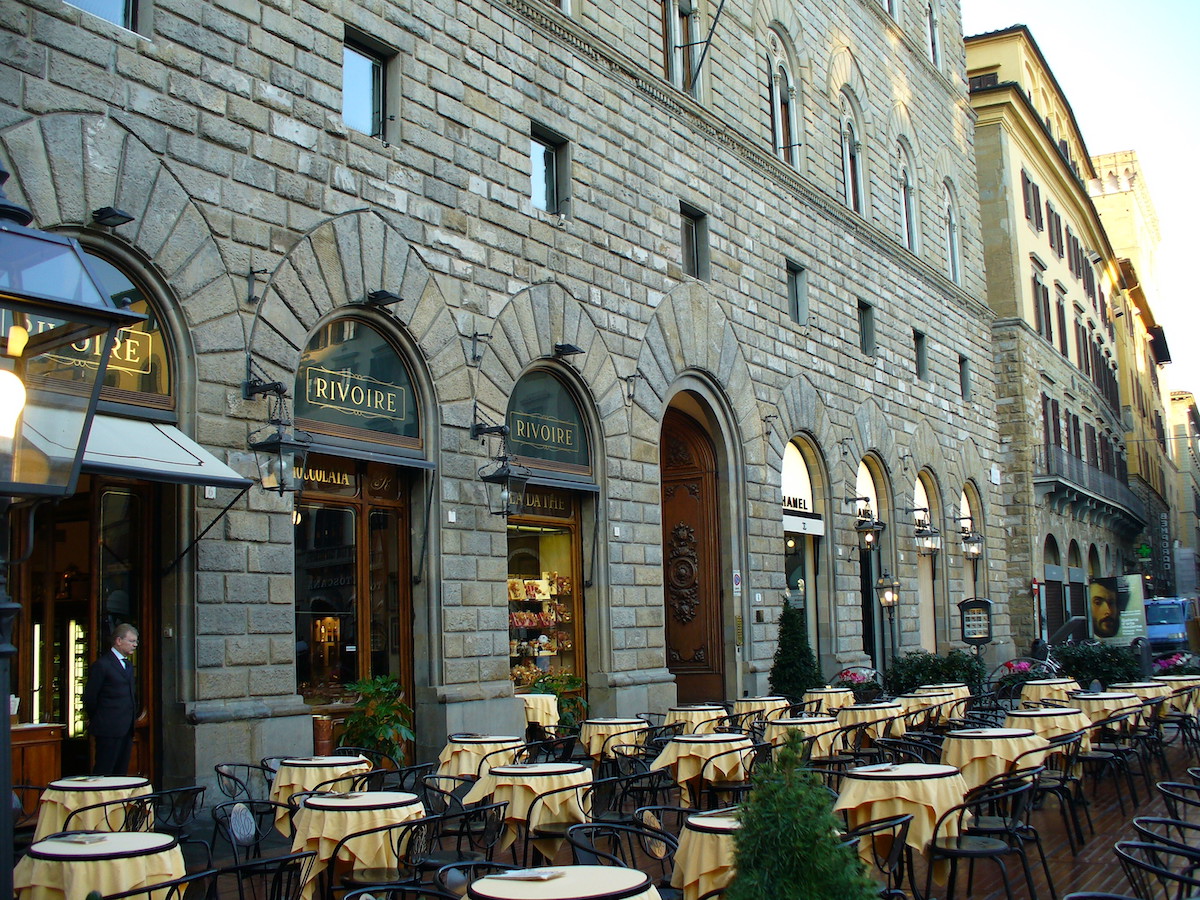 Terraza al aire libre en la cafetería Rivoire en Florencia fuera de un gran edificio de piedra