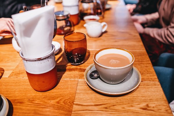 Una taza de té con leche sobre la mesa