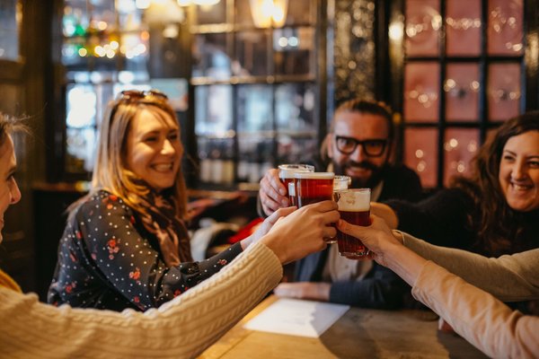 Un grupo de amigos brindando con cerveza en un pub de Londres