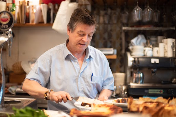 Santiago Rivera, dueño del bar La Viña, emplatando un cheesecake