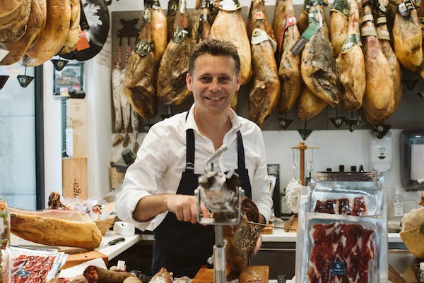 Sylvain, propietario de la tienda gourmet Zapore Jai, cortando jamón ibérico
