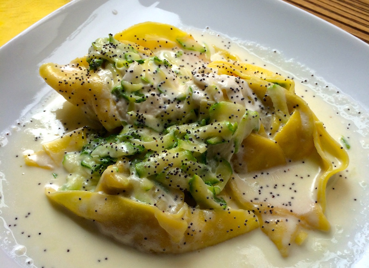 Fideos de pasta grandes en salsa de crema ligera con vegetales verdes y semillas de amapola
